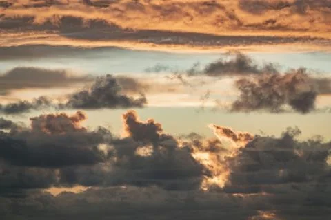 Evening sun hiding behind clouds Stock Photos