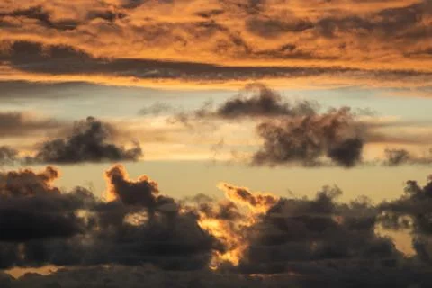 Evening sun hiding behind clouds Stock Photos