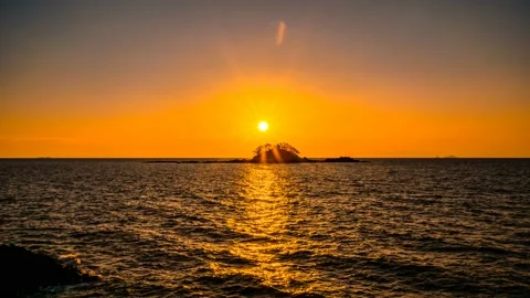 The evening sun is over a small reef above the sea. Stock Footage 145702318