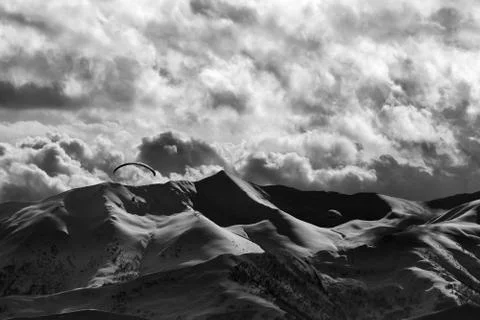 Evening sunlight mountain with clouds and silhouette of paraglider Stock Photos