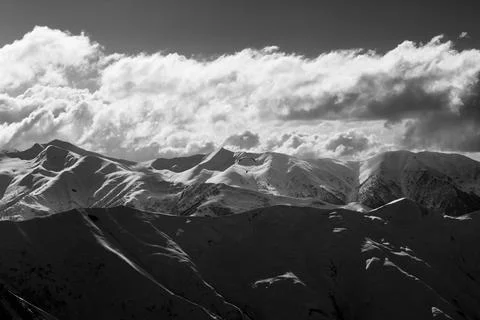 Evening sunlight mountain with clouds and silhouette of paraglider. Black and Stock Photos