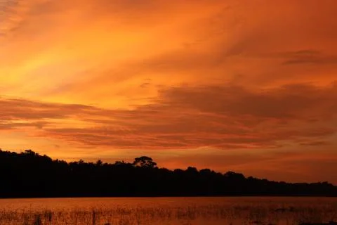 The evening sunlight is reflected in the river below. Stock Photos