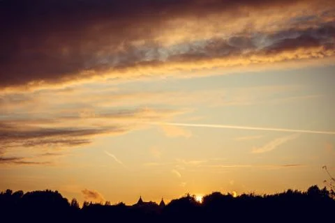 Evening sunset with clouds on the background of the shadows of buildings Stock Photos