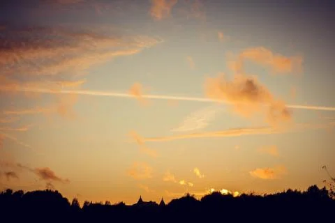 Evening sunset with clouds on the background of the shadows of buildings Stock Photos