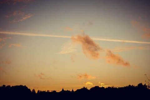 Evening sunset with clouds on the background of the shadows of buildings Фото