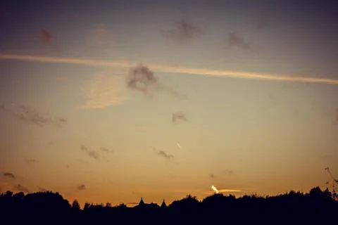 Evening sunset with clouds on the background of the shadows of buildings Stock Photos