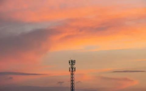 Evening sunset light is orange after the telephone receiver antenna. Stock Photos