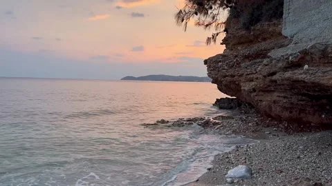 Evening. Sunset. The sea is colored pink and pearly from the setting sun. Stock Footage 288341759