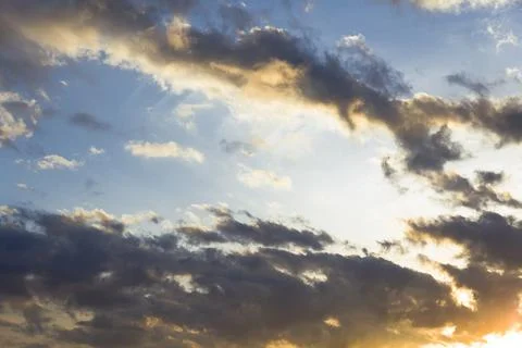 Evening sunset, sky above the clouds with dramatic yellow light. Stock Photos