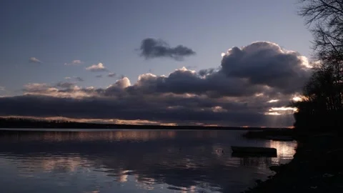 Evening sunset sky over the river. There is a boat in the river near the shore Stock Footage 292818110