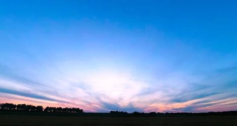 Evening sunset sun over the fields in red-blue tones Stock Photos