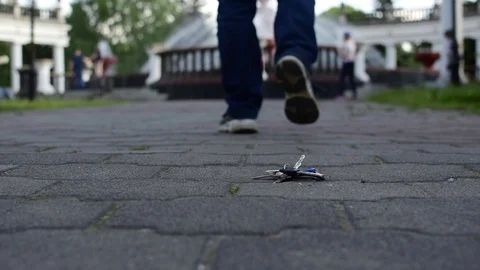 Evening time, the guy in the Park with the fountain dropped a bunch of keys Stock Footage 114690789