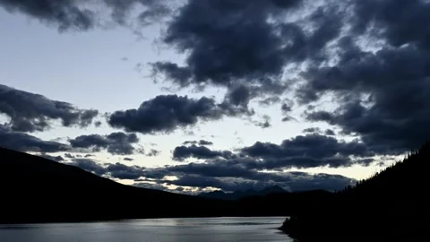 An evening time lapse in a mountain setting with a large lake reflecting clouds Stock Footage 142528488