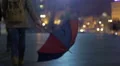 Evening time, woman with unfolded umbrella walking down the street, sadness HD Footage
