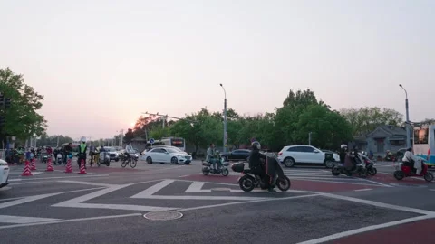Evening traffic at Beijing intersection with scooters, cars, and pedestrians Stock Footage 334966757