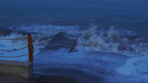 Evening twilight at sea. Waves beat on the concrete pier. Видео 166487994