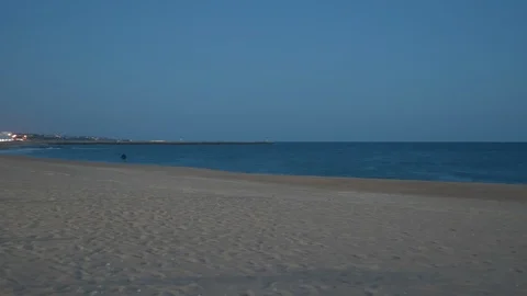 Evening view across the beach out to sea as the camera pans round Stock Footage 106498100