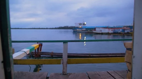 Evening view of a boat pulling in to dock for the night. Railings and Stock Footage 105109819