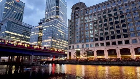 Evening view of Canary Wharf with modern buildings, DLR train, and water Vídeos de archivo 314362758