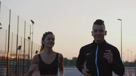 Evening view of a couple jogging Stock Footage 100033296