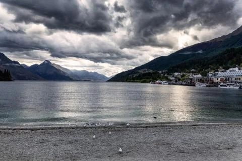 Evening view of dramatic clouds over Wakatipu lake and mountains of Queenstow Stock Photos