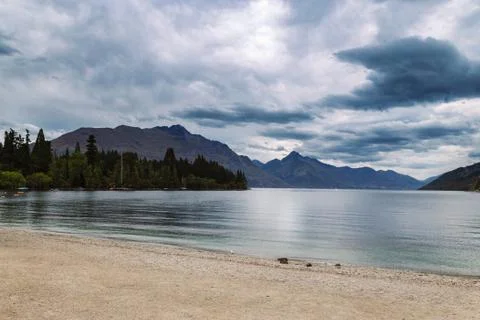 Evening view of dramatic clouds over Wakatipu lake and mountains of Queenstow Stock Photos