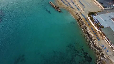 Evening view of the empty evening beach with white sand, stones, resort and a wo Stock Footage 107064853