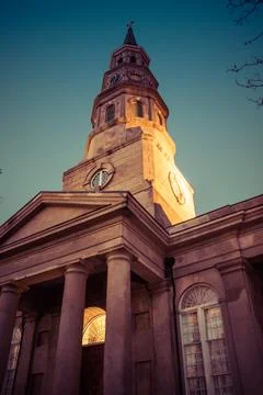 An evening view looking up at the steeple of an old church in Charleston. Stockfoto's