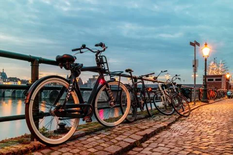 Evening view of parked bicycles alongside the Dutch river Maas Фото