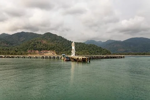 Evening view from ship deck, Koh Chang, Thailand: lighthouse and colorful boats Stock Photos