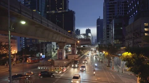 Evening view of skytrain passing above Sathon Road in Bangkok Stock Footage 99132253