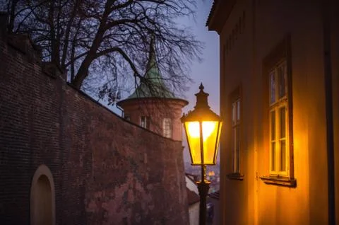 Evening view at the small streets of Prague Castle with old street lamps lit  Stock Photos