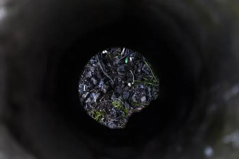 Evening view through a dark abandoned pipe 写真素材
