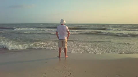 Evening Waves: Man in Bucket Hat Relishing the Summer Sea Stock Footage 281630731