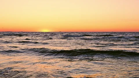 Evening waves rolling across Baltic Sea onto sandy shoreline beneath  sunset. Stock Footage 341670102