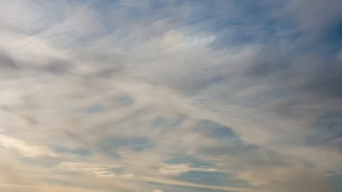 Evening white clouds float across the sky, time laps Stock Footage 128756448