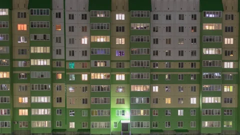 The evening windows of the apartment building turn on and off their lighting. Stock Footage 129507048
