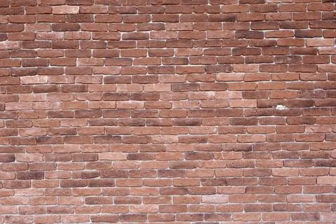 Evenly aligned red brick wall texture captured in daylight. Stock Photos