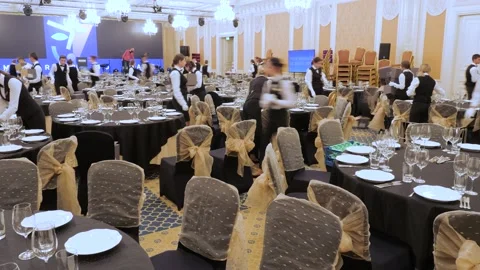 Event center serving staff setting table banquet room. Serving table banquet Stock Footage 163344026