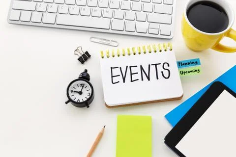 Event planning with clock notepad and coffee cup on computer office desk with Stock Photos