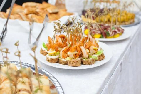 Event with various appetizers on a table with a white tablecloth Stock Photos