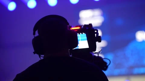 Event videographer filming stage performance with professional camera rig Stock Footage 322153378