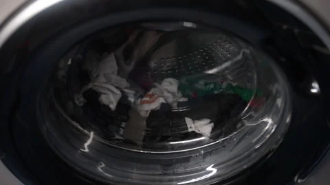 Everyday chore of laundry - washing machine drum spinning with socks and laundry Stock Footage 293513015