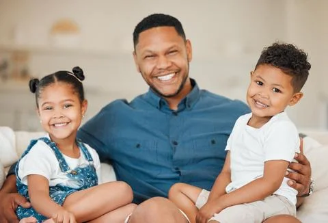 Everything else comes second. a young father sitting on the sofa at home with Stock Photos