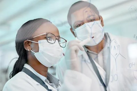Everything has to add up. two scientists drawing molecular structures on a glass Stock Photos