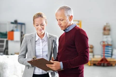 Everything seems satisfactory. two warehouse managers on the factory floor. Stock Photos