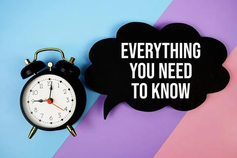 Everything You Need To Know text on speech bubble with alarm clock top view.. Stock Photos