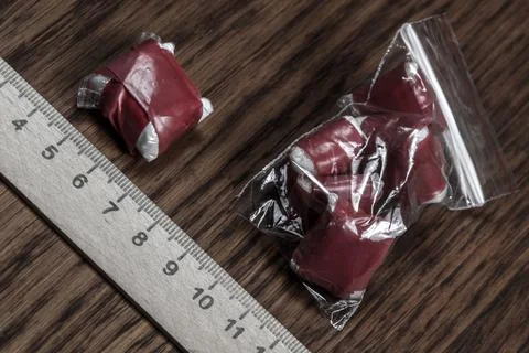 Evidence of smuggling traffic: packaging of an unknown drug next to the foren Stock Photos