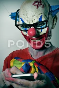 Evil clown using a smartphone Stock Photos