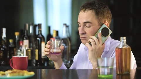 An evil drunk businessman talking on phone while holding a glass of alcohol in Stock Footage 301681092